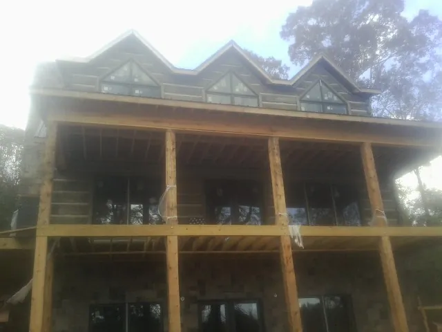 Dormers and porch framing on a large log home under construction — Roof Coating work by our crew in Fort Jones
