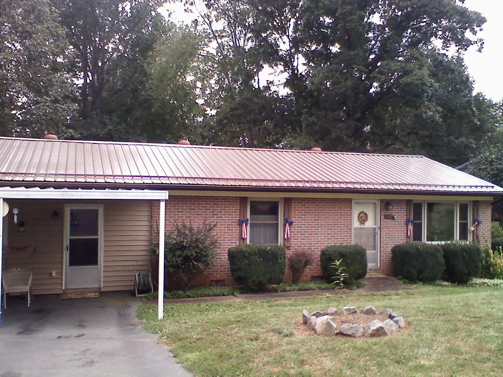 Bronze metal roof and carport on a brick ranch home — Roof Repair work by our crew in Fort Jones